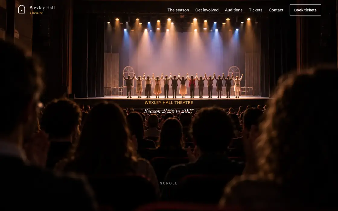 The theatre microsite on a laptop: a cast taking a bow on a lit stage seen from the back of the auditorium
